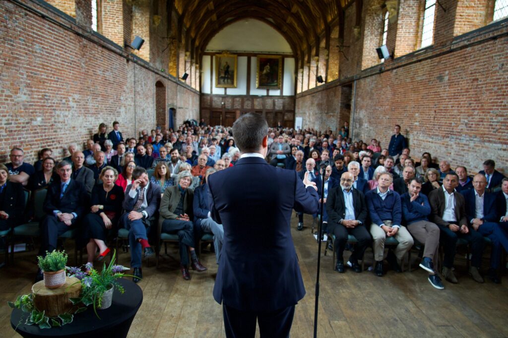 Robert Jenrick speaks to a packed hall in the Old Palace at Hatfield House. Your author can just be seen on the left, four rows back behind Jacob Rees Mogg.